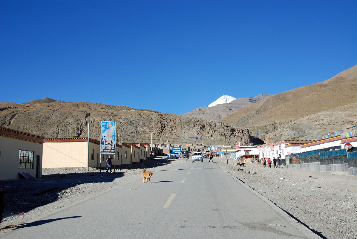 42 Main Street In Darchen Tibet With Mount Kailash Behind The main street in Darchen (4681m) stretches uphill with Mount Kailash poking up above the horizon ridge.
